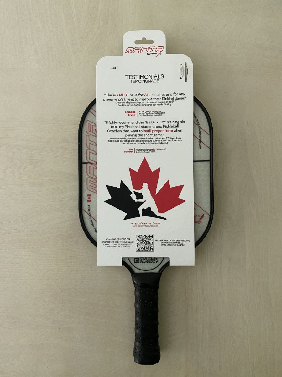 Pickleball paddle with packaging featuring a maple leaf design on a beige surface